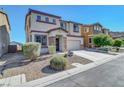 Two-story home with a two-car garage, rock accents, and low-maintenance landscaping in a residential neighborhood at 405 Prairie Moon Ave, North Las Vegas, NV 89084