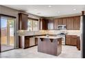 Well-lit kitchen featuring wood cabinets, stainless steel appliances, and granite countertops at 405 Prairie Moon Ave, North Las Vegas, NV 89084