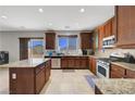 Spacious kitchen featuring an island with granite countertops, stainless steel appliances, and wood cabinets at 405 Prairie Moon Ave, North Las Vegas, NV 89084