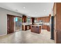 Spacious kitchen featuring wood cabinetry, stainless steel appliances, granite counters, and tile flooring at 405 Prairie Moon Ave, North Las Vegas, NV 89084