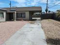 Long driveway leading to covered parking with desert landscaping and a privacy fence at 4525 Fulton Pl, Las Vegas, NV 89107