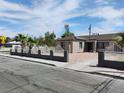 Attractive single-story home with light brown siding, gated yard and rock landscaping at 4525 Fulton Pl, Las Vegas, NV 89107