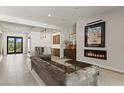 Bright open-concept living space with bar area, modern fireplace, and neutral color palette at 47 Garibaldi Way, Henderson, NV 89011
