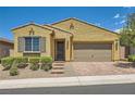 Charming single-story home with a two-car garage, desert landscaping, and a brick driveway at 498 Pebble Run Ave, Henderson, NV 89011