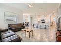 Open-concept living area with tile floors, a ceiling fan, and a seamless flow into the kitchen at 498 Pebble Run Ave, Henderson, NV 89011