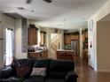 Inviting living room flows into a spacious kitchen with a central island and stainless steel refrigerator at 5043 Gable Crest Ct, Las Vegas, NV 89141