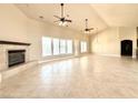 Expansive living room with a fireplace, large windows, and modern ceiling fans at 5451 Fernwood Ct, Pahrump, NV 89061