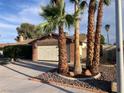 Single-story home with brick and siding exterior with desert landscaping and attached garage with a white door at 5821 Santa Catalina Ave, Las Vegas, NV 89108