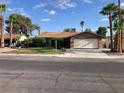 Charming single-story home featuring a lush front lawn, palm trees, and a two-car garage at 5821 Santa Catalina Ave, Las Vegas, NV 89108