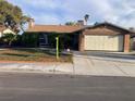 Charming single-story home featuring a lush front lawn, mature trees, and a two-car garage at 5821 Santa Catalina Ave, Las Vegas, NV 89108