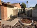 Home exterior featuring decorative gates with stone landscaping, brick accents, and mature trees at 5821 Santa Catalina Ave, Las Vegas, NV 89108