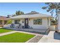 Attractive one-story home featuring a well-kept lawn and a cozy front porch with chairs at 615 D Ave, Boulder City, NV 89005