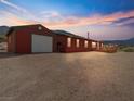 Exterior of home and garage with a green roof and a large gravel area in front at 70 Camp Bonanza Rd, Las Vegas, NV 89124