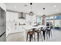Sleek kitchen featuring a center island with seating, stainless appliances, and bright white cabinetry at 7107 Tilligerry St, North Las Vegas, NV 89084