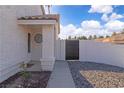 View of the front entrance with a gate, textured facade, and stone landscaping at 765 Butternut Ct, Henderson, NV 89014