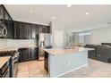 Open kitchen with granite countertops, stainless steel appliances, and tile flooring at 7761 Sagamore Bay Ct, Las Vegas, NV 89179