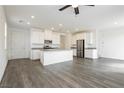 Open-concept kitchen with gray countertops, stainless steel appliances, white cabinetry and modern gray wood flooring at 7777 Vino Vranec Ct, Las Vegas, NV 89113