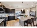 Modern kitchen with black cabinetry, stainless steel appliances, granite countertops, and island with barstool seating at 8042 Misty Canyon Ave, Las Vegas, NV 89113