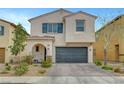 Charming two-story home featuring a neutral stucco exterior, arched entryway, and attached two-car garage at , Las Vegas, NV 89139