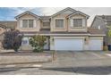 Two-story home with a three-car garage and a well-manicured front yard featuring desert landscaping at 104 Glendive St, Henderson, NV 89012