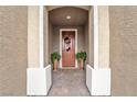 Inviting front entrance with a decorated door, stylish brickwork, and charming potted plants at 10601 Skye Arroyo Ave, Las Vegas, NV 89166