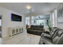 Bright living room featuring tiled floors, a media cabinet and a reclining sofa with cup holders at 11004 Napa Ridge Dr, Las Vegas, NV 89144