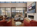 A living room featuring hardwood floors, a fireplace, and large windows that bring in ample natural light and views at 11707 Discovery Canyon Dr, Las Vegas, NV 89135