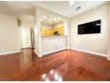 Open living room featuring hardwood floors, large tv, and seamless flow to the kitchen at 1201 Dusty Creek St, Las Vegas, NV 89128