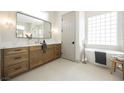 Bathroom with a soaking tub, walk-in shower, and dual vanity with wood cabinets and modern fixtures at 2177 Magnolia Pond Ct, Henderson, NV 89052