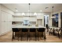 Spacious kitchen featuring a large island with bar seating, modern appliances, and bright lighting fixtures at 2177 Magnolia Pond Ct, Henderson, NV 89052