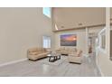 Bright living room with high ceilings, neutral decor, and tile flooring at 2382 Sunburst View St, Henderson, NV 89052