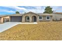 Charming single-story home with attached garage, desert landscaping, and an arched front entryway at 239 Concho Dr, Henderson, NV 89015