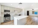 Modern kitchen with new stainless steel appliances, an island, and sleek countertops at 239 Concho Dr, Henderson, NV 89015
