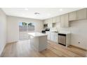 Well-lit kitchen with stainless steel appliances, an island with white countertop, and backyard sliding glass doors at 239 Concho Dr, Henderson, NV 89015