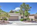 Single-story home with desert landscaping, tan stucco, and a two-car garage at 2509 Banora Point Dr, Las Vegas, NV 89134