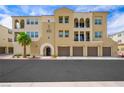 Inviting condo building featuring a three car garage, palm tree, and well manicured bushes in front at 2555 Hampton Rd # 9307, Henderson, NV 89052