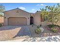 Charming single-story home featuring a desert landscape, and a two car garage on a sunny day at 305 Via Del Duomo, Henderson, NV 89011