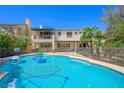 Backyard pool with safety fence, solar panels, and lounge area at 335 Pleasant Summit Dr, Henderson, NV 89012