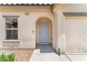 A close-up shot of the front door of a home, featuring an arched entrance and a single-car garage at 4252 Olympic Point Dr, Las Vegas, NV 89129