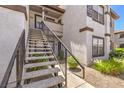 Stairwell for an upstairs unit features a textured walkway and lush shrubbery on either side, creating an inviting entry at 45 Maleena Mesa St # 1321, Henderson, NV 89074