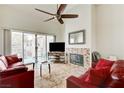 Cozy living room with high ceiling, fireplace, tile floors, and sliding glass doors to a patio at 5000 Red Rock St # 248, Las Vegas, NV 89118