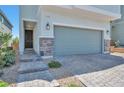 Close up of charming two-story home featuring an attached garage and stone veneer accents at 5398 Robinera Ct, Las Vegas, NV 89166