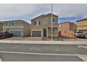 Two-story tan home with a two car garage and manicured front yard featuring easy to care for landscaping at 6207 Hamilton Ave, Las Vegas, NV 89122