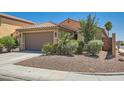 Well-maintained single-story home with a two-car garage, desert landscaping, and a tile roof at 6446 Button Quail St, North Las Vegas, NV 89084