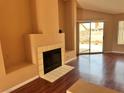 Cozy living room featuring a tiled fireplace, hardwood floors, and sliding glass doors at 6600 Silver Penny Ave, Las Vegas, NV 89108