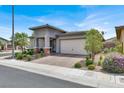 Beautiful single-story home with well-manicured landscaping and a brick driveway at 676 Otter Brook St, Henderson, NV 89011