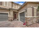 Charming home exterior featuring brick driveway, stone accents, and a welcoming front door with a wreath at 689 Sea Star St, Henderson, NV 89002