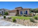 Front exterior showcasing desert landscape, manicured lawn, and charming architectural details at 724 Smokey Mountain Ave, Henderson, NV 89012