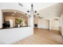 Open concept living space with modern chandelier lighting adjoining the kitchen and dining areas at 7316 Childers Ave, Las Vegas, NV 89178