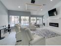 Bright living room with modern lighting, fireplace, and views of the outdoor pool at 8150 Beaverbrook Way, Las Vegas, NV 89123